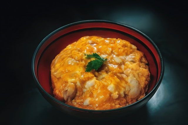 濃厚な卵黄とネギが乗った、名古屋コーチン親子丼のイラスト。