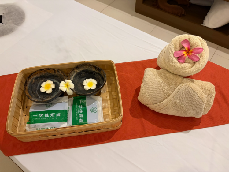 マッサージベッドの上に置かれたお花とタオルの装飾