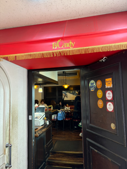 百名店のステッカーが貼られたボンディ神保町本店の入り口ドア