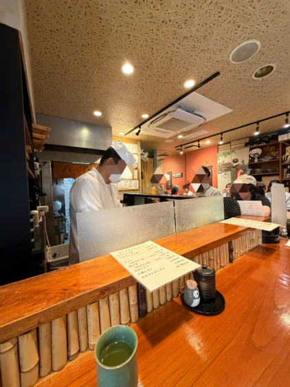 鮨わたせの店内。職人が寿司を握るカウンター席と、ランチを楽しむお客さんの様子。