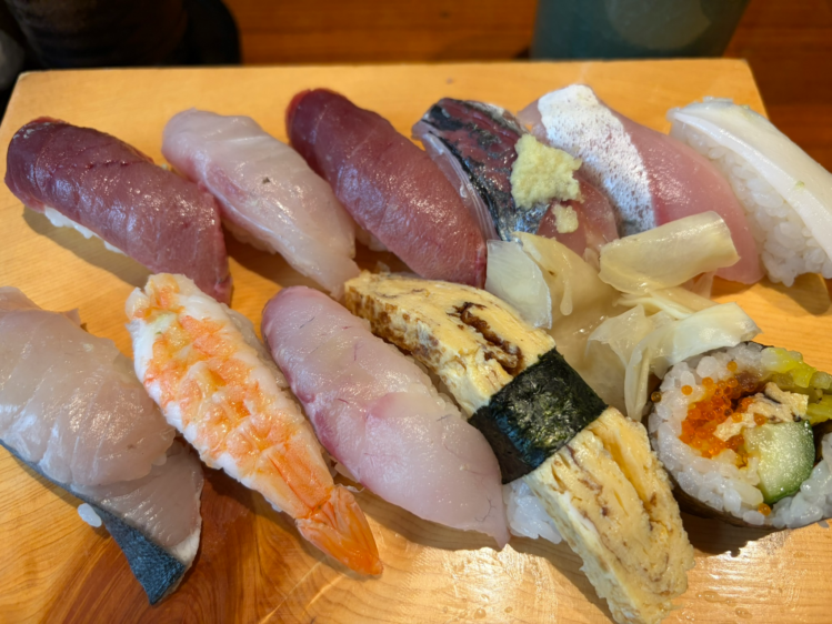 鮨わたせのランチメニュー「にぎり1.5人前」。木製の下駄に並べられた、マグロや海老、穴子、卵焼きなどの寿司の詰め合わせ。