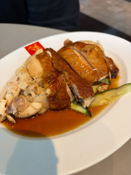 白いお皿に盛られた、こんがりと香ばしい焼き色のついたローストチキンのアップ。