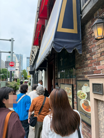 スカンディアの開店を待つ人々の列。店舗前の歩道に数人が並んでおり、順番を待っている様子が伺える。